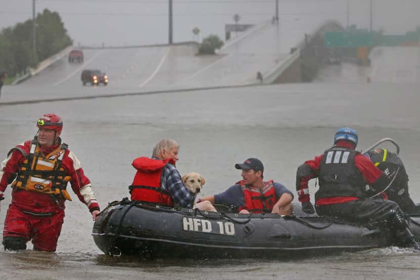 Meyerland resident Connor Childs, in orange life jacket, and his dog Lacey are rescued by...