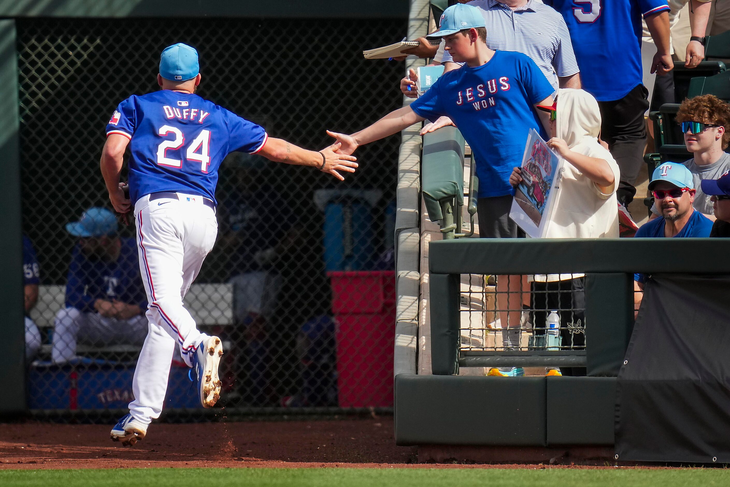 Texas Rangers pitcher Danny Duffy slaps hands with fans as he heads for the clubhouse during...