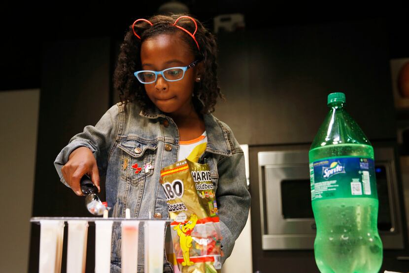 Ellington Young, 7, makes a gummy bear and lemon lime soda ice pop in Dallas.