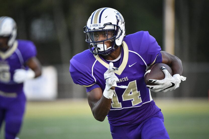 Denton wide receiver Chris Miller (14) scans the field after a catch during a high school...