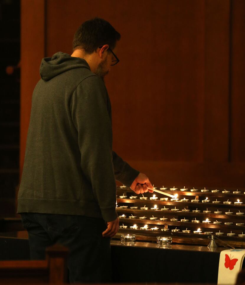Church member J.J. Heid lights a candle in the sanctuary at Grace Avenue United Methodist...