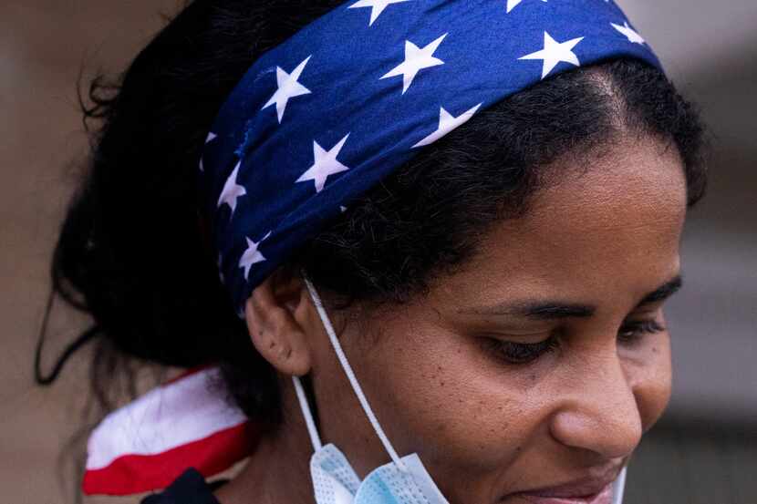 Yoima Paisan-Viltre, wearing a red-white-and-blue bandana, waits for family members after...