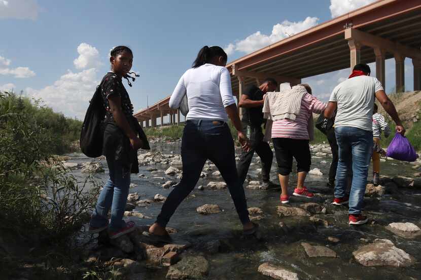 Un grupo de migrantes cruza sobre el riachuelo en el Rio Grande desde Ciudad Juárez a El...