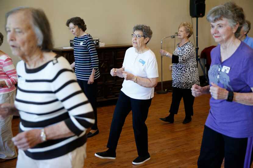 Louise Pierson (center) dances with her group during a line dancing class for seniors at...