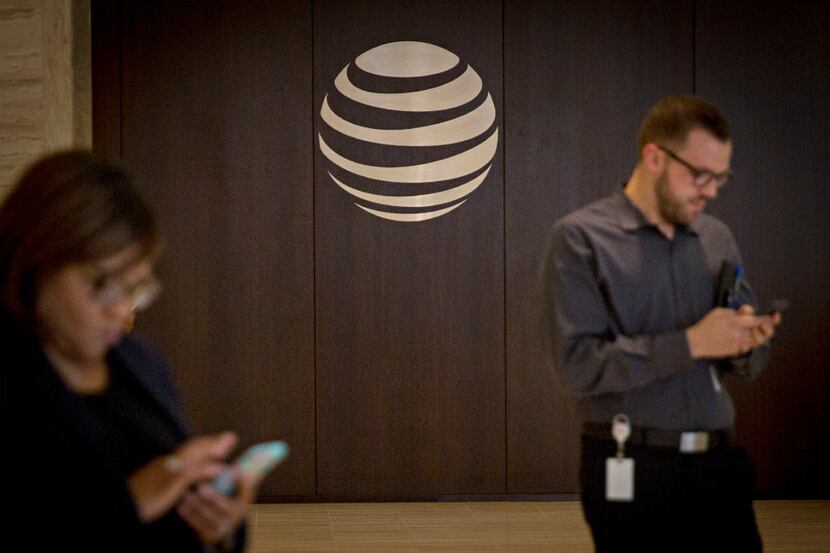 People interact with their smartphones in the lobby of AT&T's downtown headquarters building...