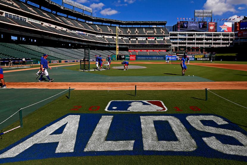 Texas Rangers players pick up baseballs after the batting practice during the team workout...