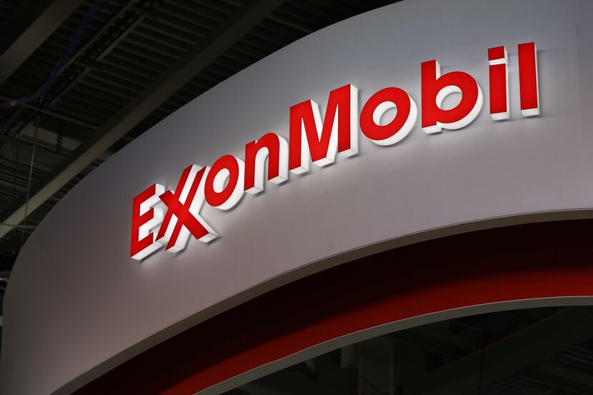 A logo sits illuminated outside the Exxon Mobil Corp. corporate pavilion during the 21st...