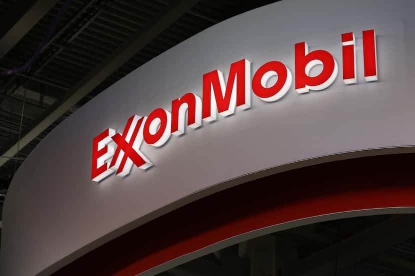 A logo sits illuminated outside the Exxon Mobil Corp. corporate pavilion during the 21st...