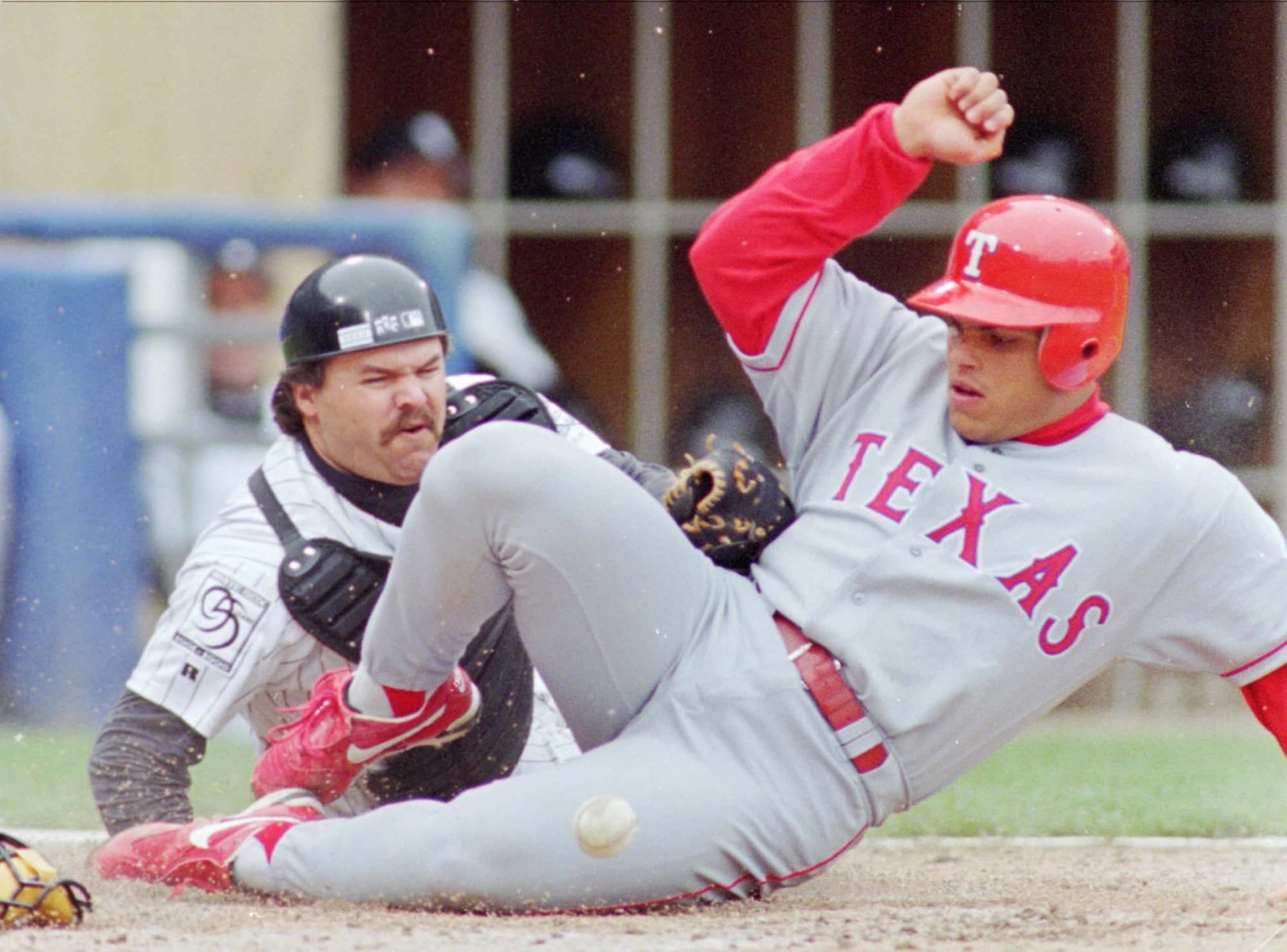 Rangers catcher Ivan Rodriguez slides safely into home in the Rangers' 1996 away grays.