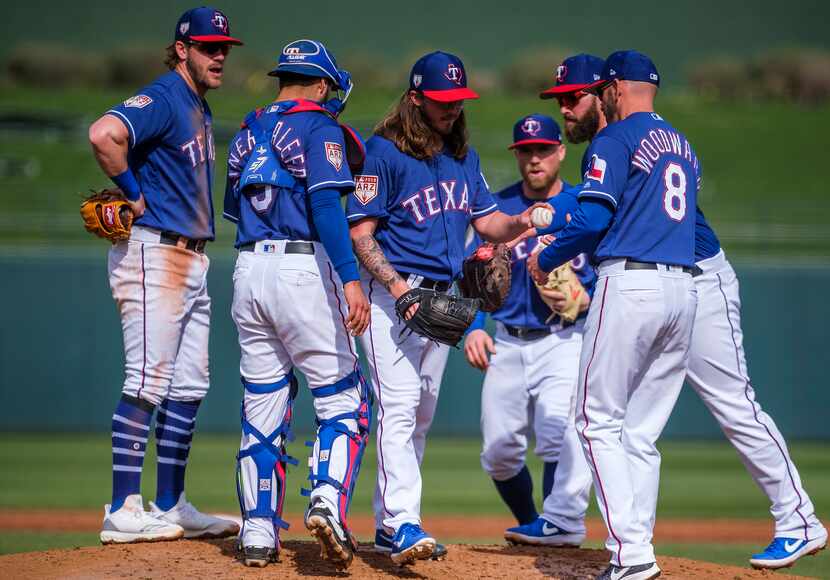 Texas Rangers pitcher Zac Curtis hands the ball over to manager Chris Woodward (8) as he is...
