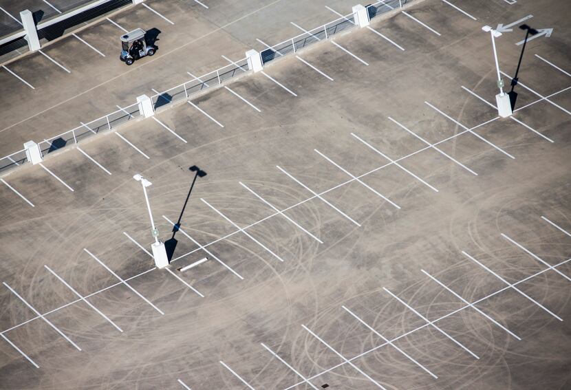 A security guard drives a golf cart past tire marks showing evidence of stunt driving on the...