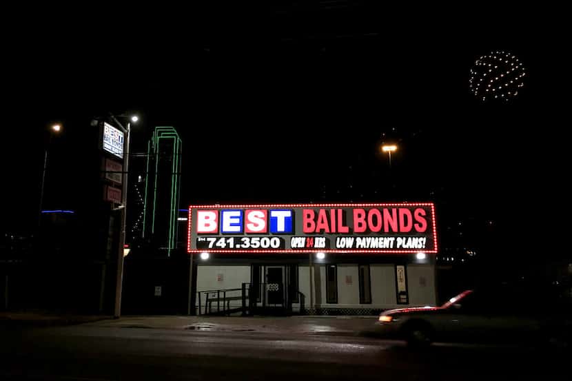 Lights from a bail bond business glow along Riverfront Blvd. in Dallas, on Sunday night,...