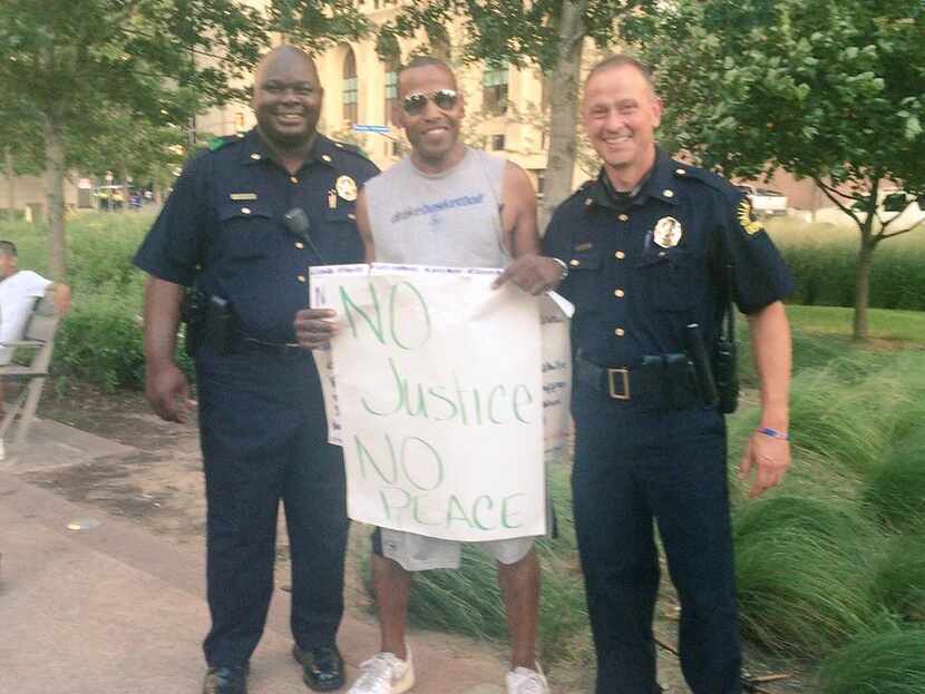 A protest participant and two Dallas police officers posed together before a peaceful rally...