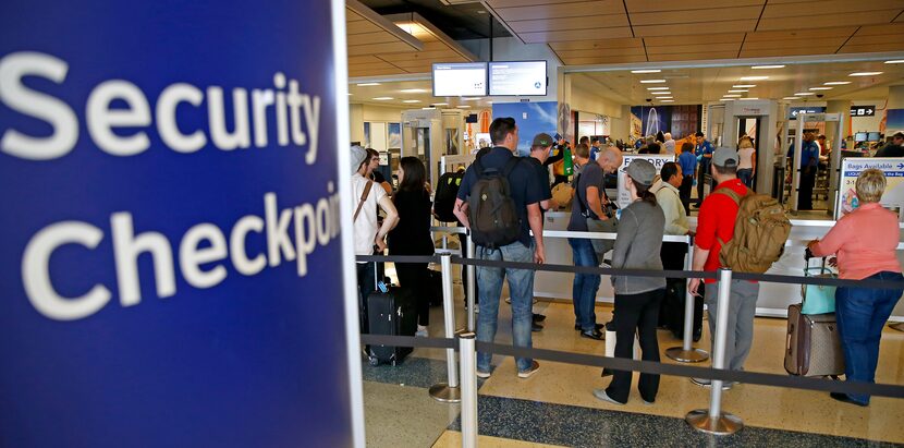 Travelers stay in line to go through the TSA security checkpoint at DFW International Airport.