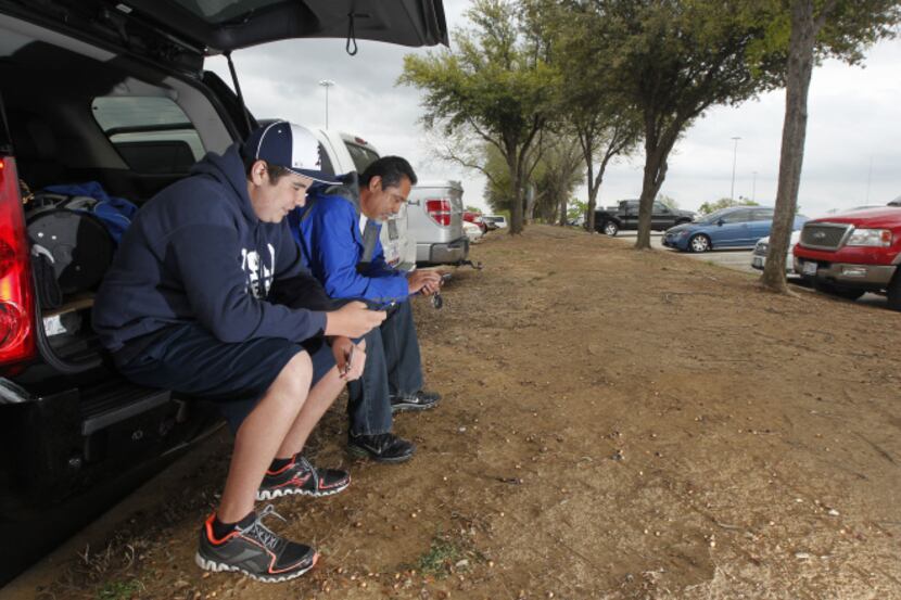 Christian Padilla (left) and his father, Juan, waited for gates to open Thursday at Rangers...