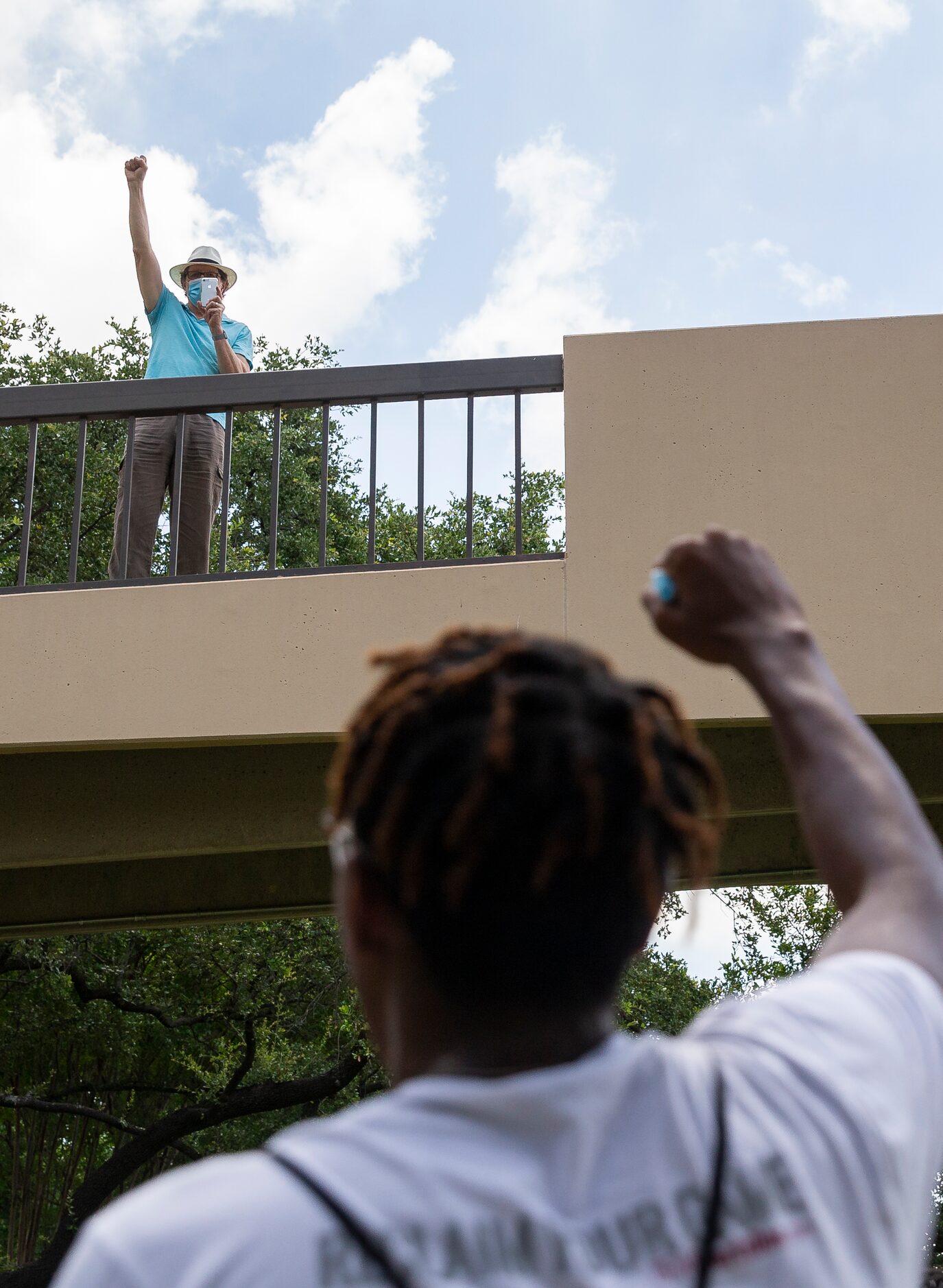 A man raises his fist with protestors as they march against police brutality around campus...