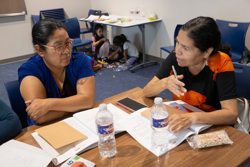 Antonina Zamvdio (left) and Delia Martinez chat during a small group discussion during a...