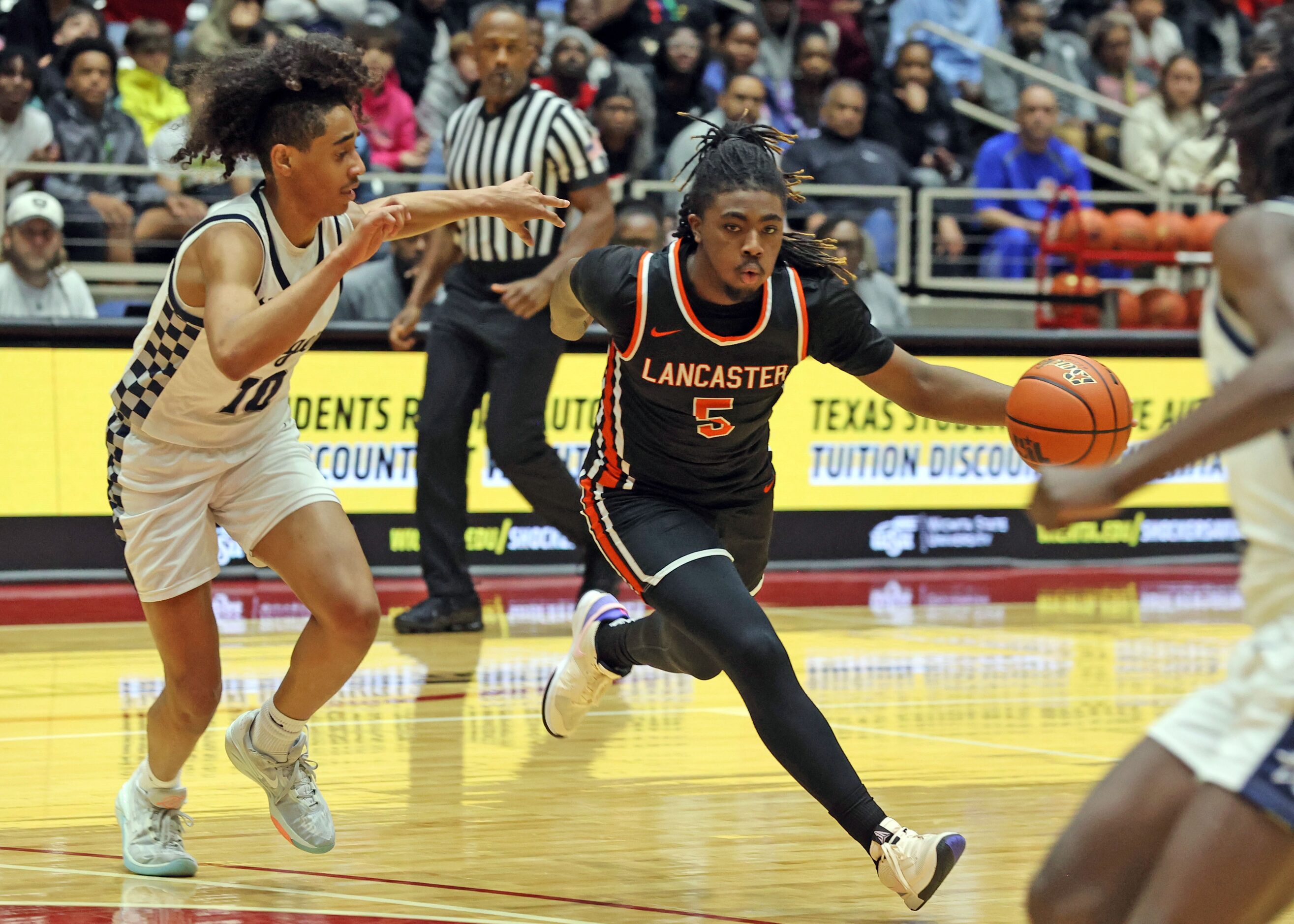 Lancaster's Mario Perry (5) brings the ball past Frisco Lone Star G Quincy Baker (10) during...