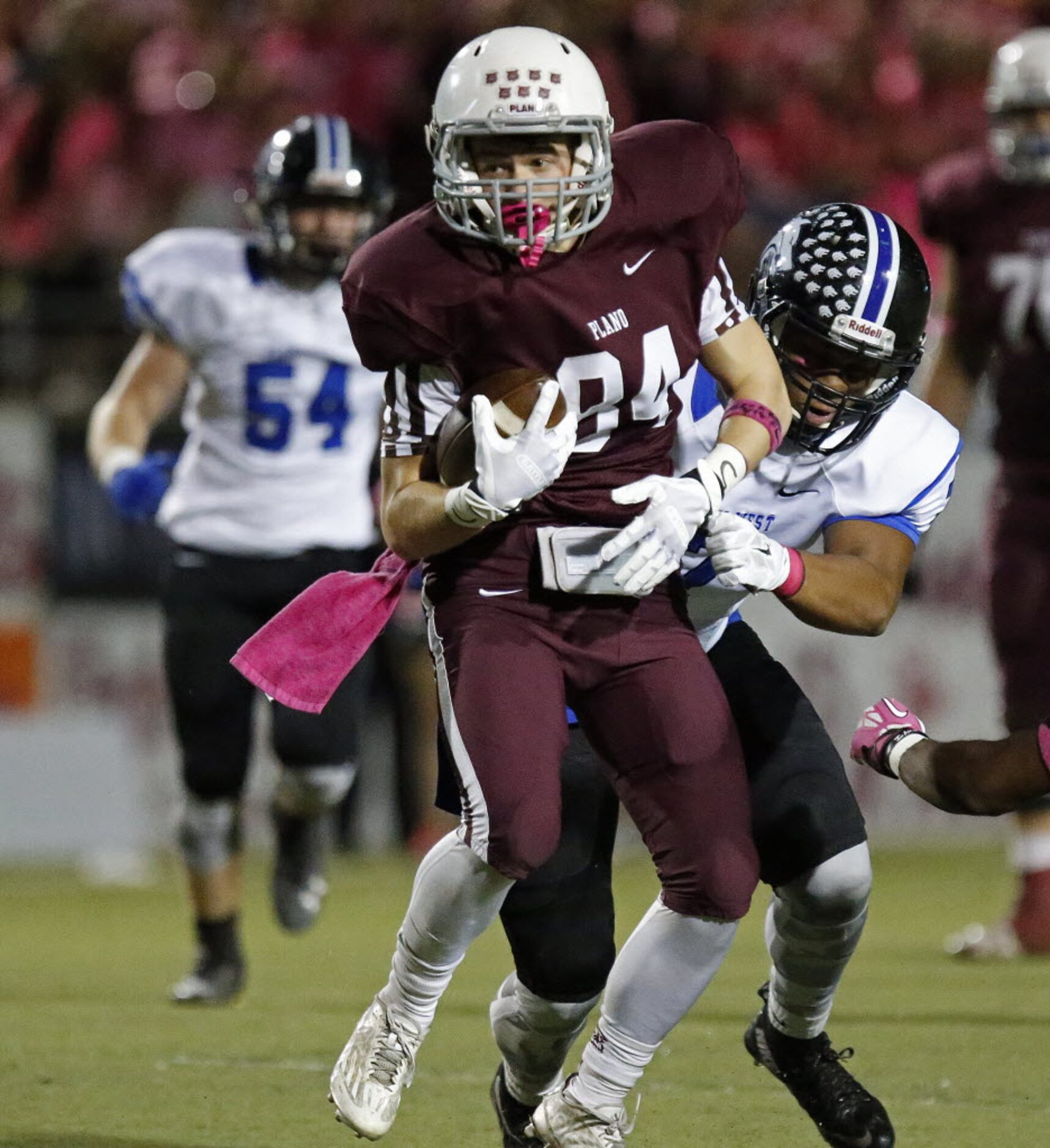 Plano High School wide receiver Garrett Frederick (84) is brought down after a big gain by...