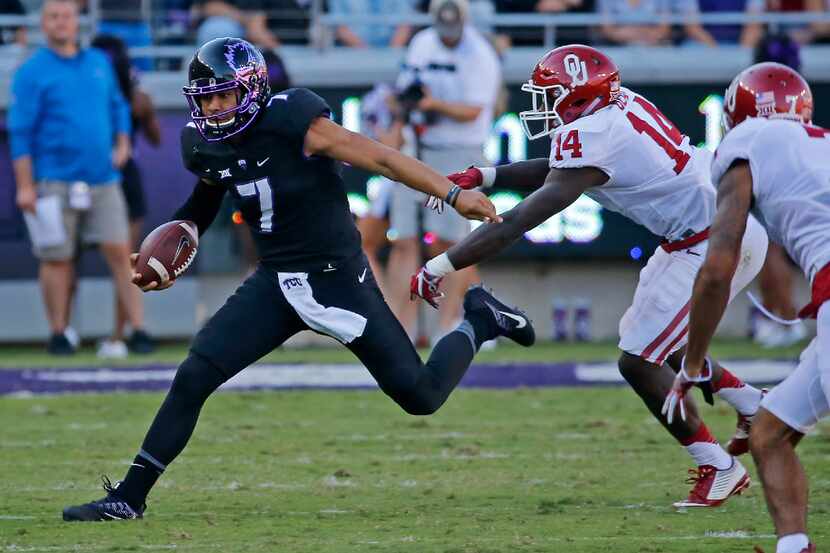 TCU quarterback Kenny Hill (7) is chased by Oklahoma linebacker Emmanuel Beal (14) during...