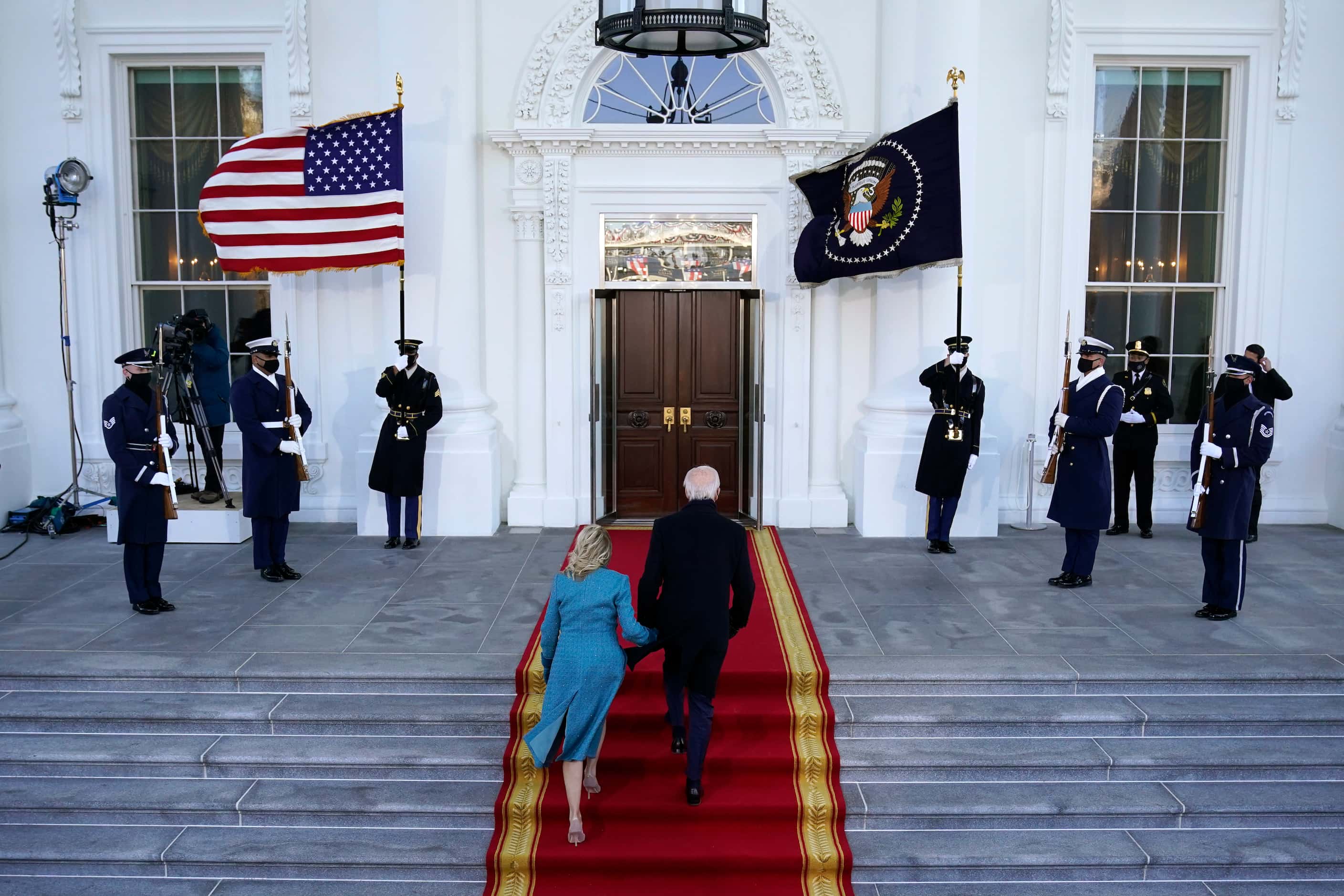 President Joe Biden and first lady Jill Biden walk up the stairs as they arrive at the North...