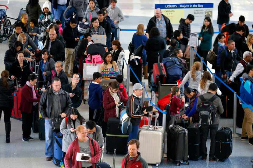 American Airlines passengers wait in a long line to get checked in at Terminal D at DFW...