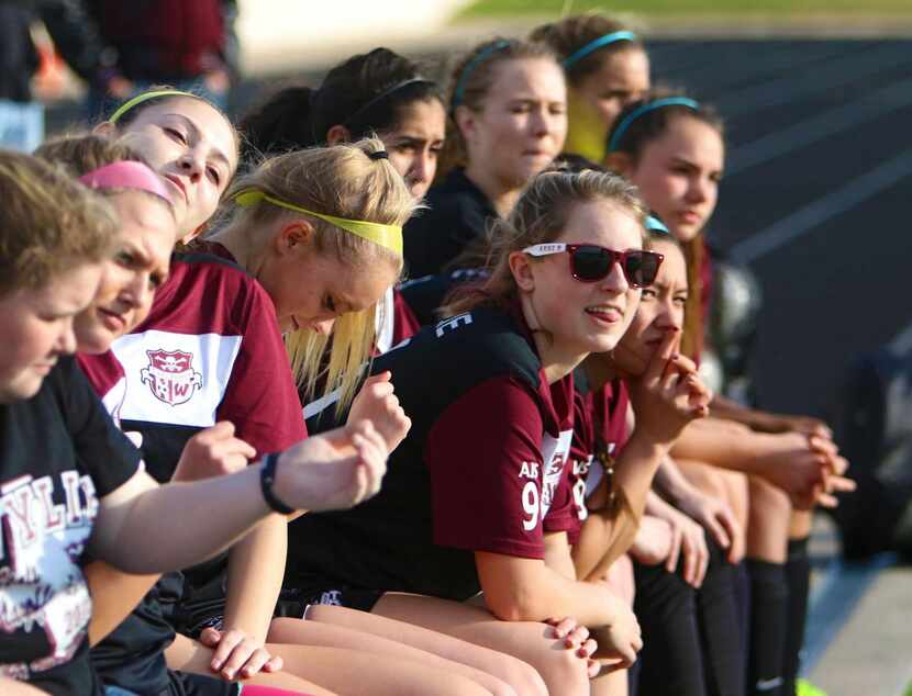 
Members of the Wylie varsity girls soccer team watch their teammates on the field during...