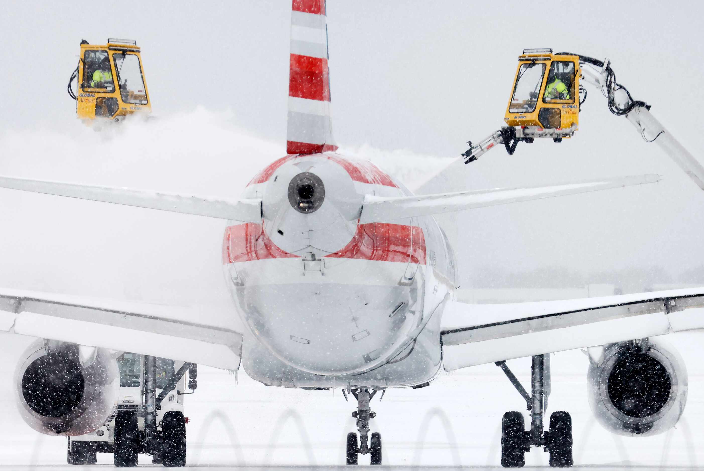 Aerial crews deice an American Airlines jet before it can take off at DFW Airport’s Terminal...