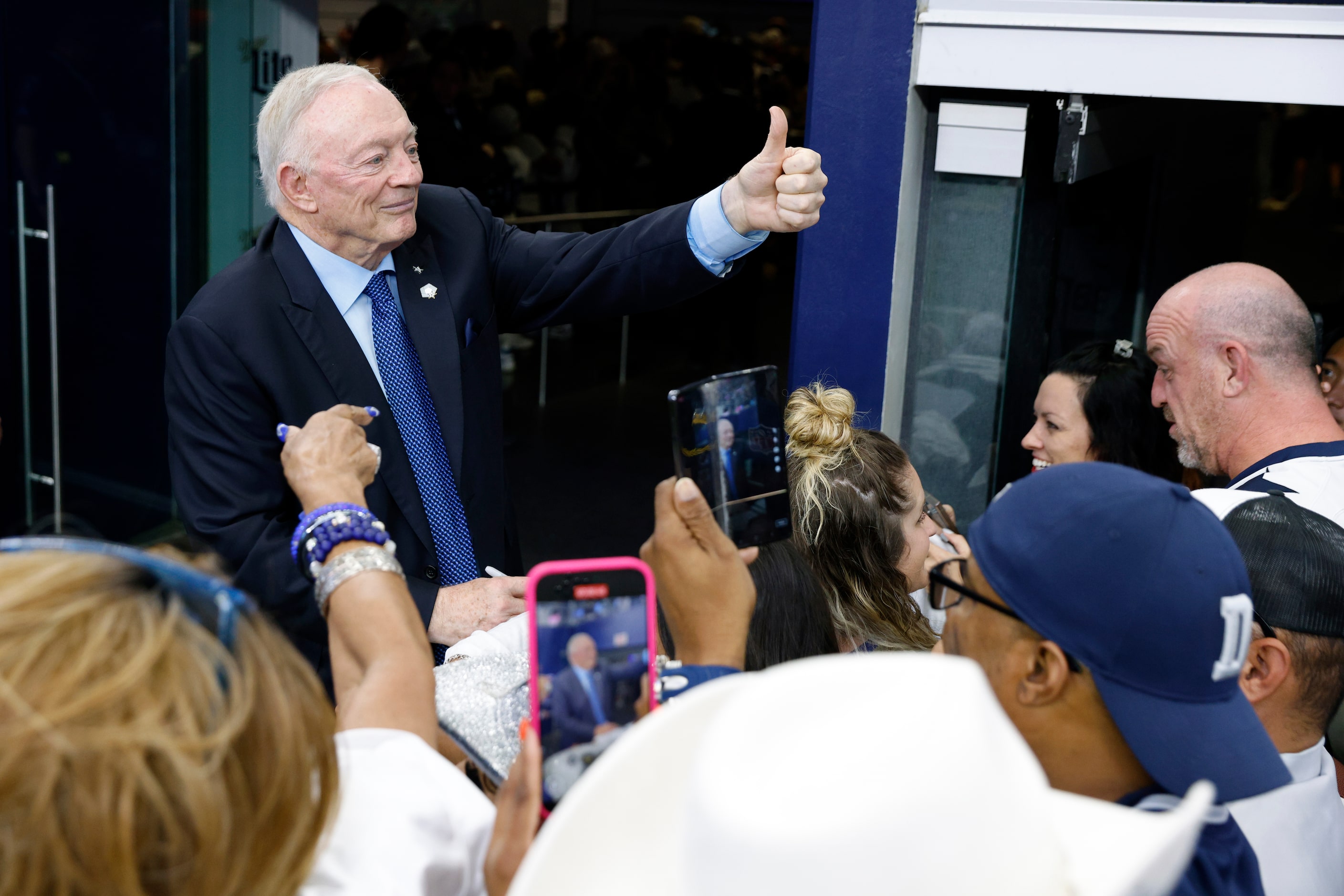 Dallas Cowboys owner and general manager Jerry Jones gives a thumbs-up to fans as he signs...