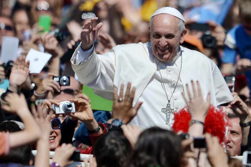 Pope Francis greets the crowd after the Easter mass on April 20, 2014 at St Peter's square...