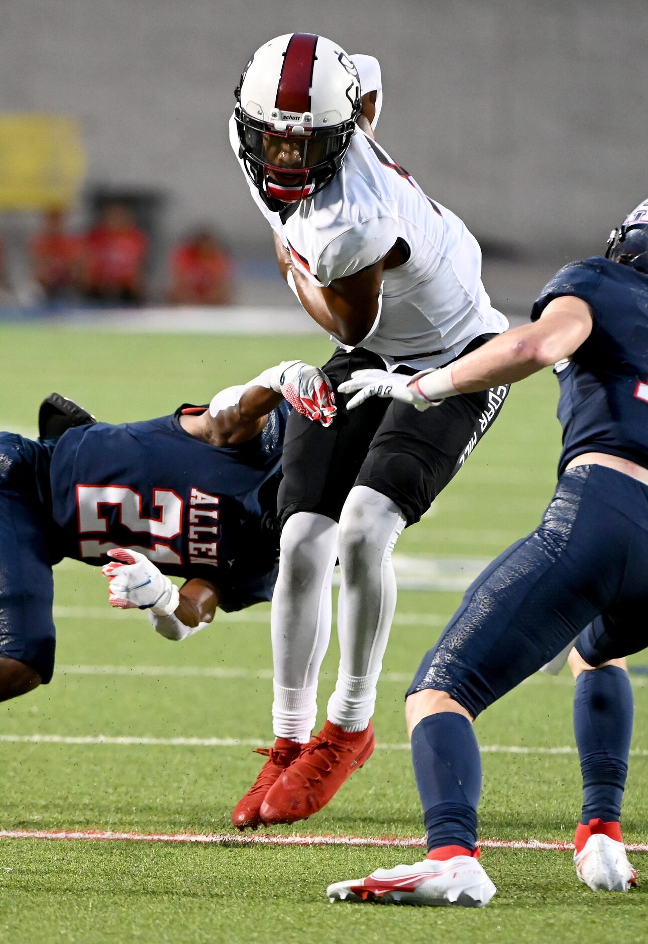 Cedar Hill's Cedric Harden Jr. (5) runs between Allen’s Nicholas Bargains (21) and...