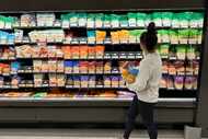 A shopper peruses the refrigerated cheese offerings in a Target store Oct. 4, 2023, in...