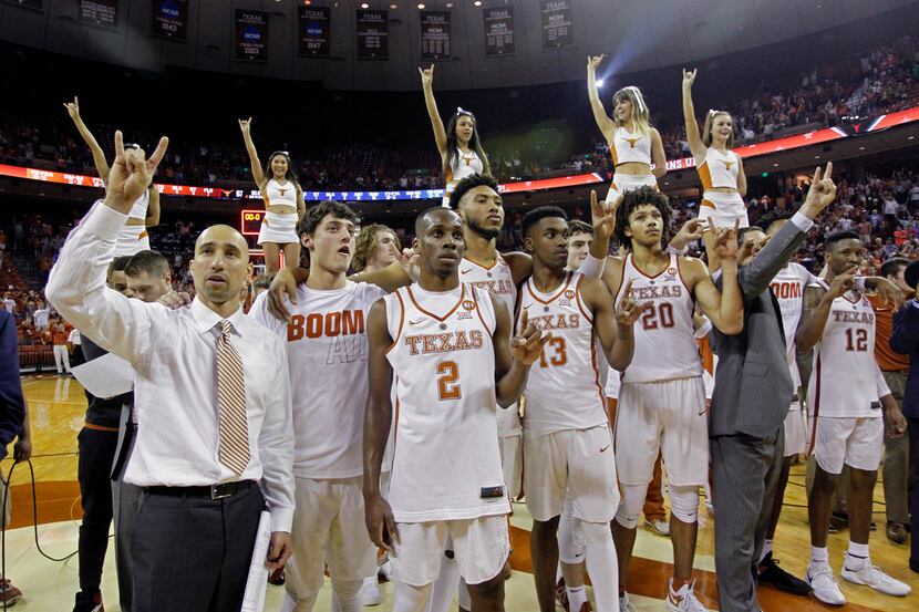Texas head coach Shaka Smart, left, sings the "Eyes of Texas" with his team after defeating...