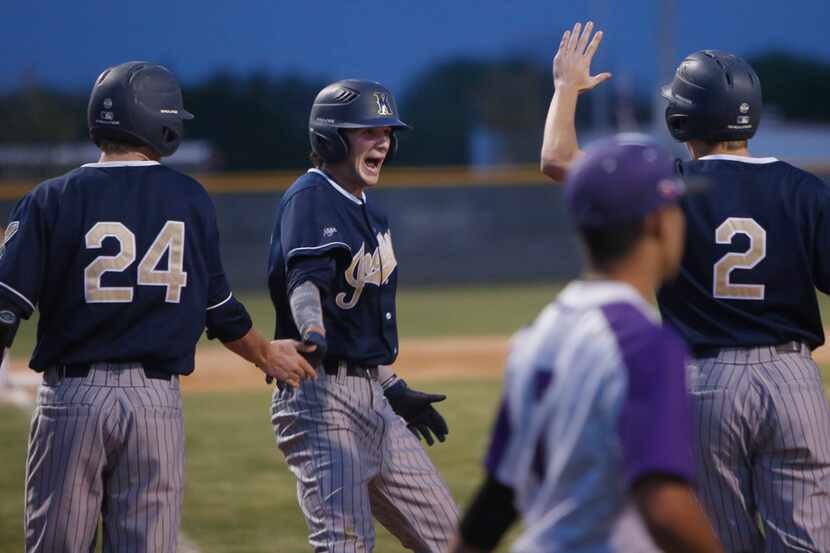 Keller's Will Lance (13) was all smiles as he touches home plate and is congratulated by...