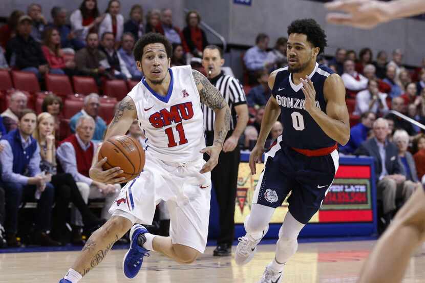SMU guard Nic Moore (11) drives to the goal past Gonzaga guard Silas Melson (0) during the...