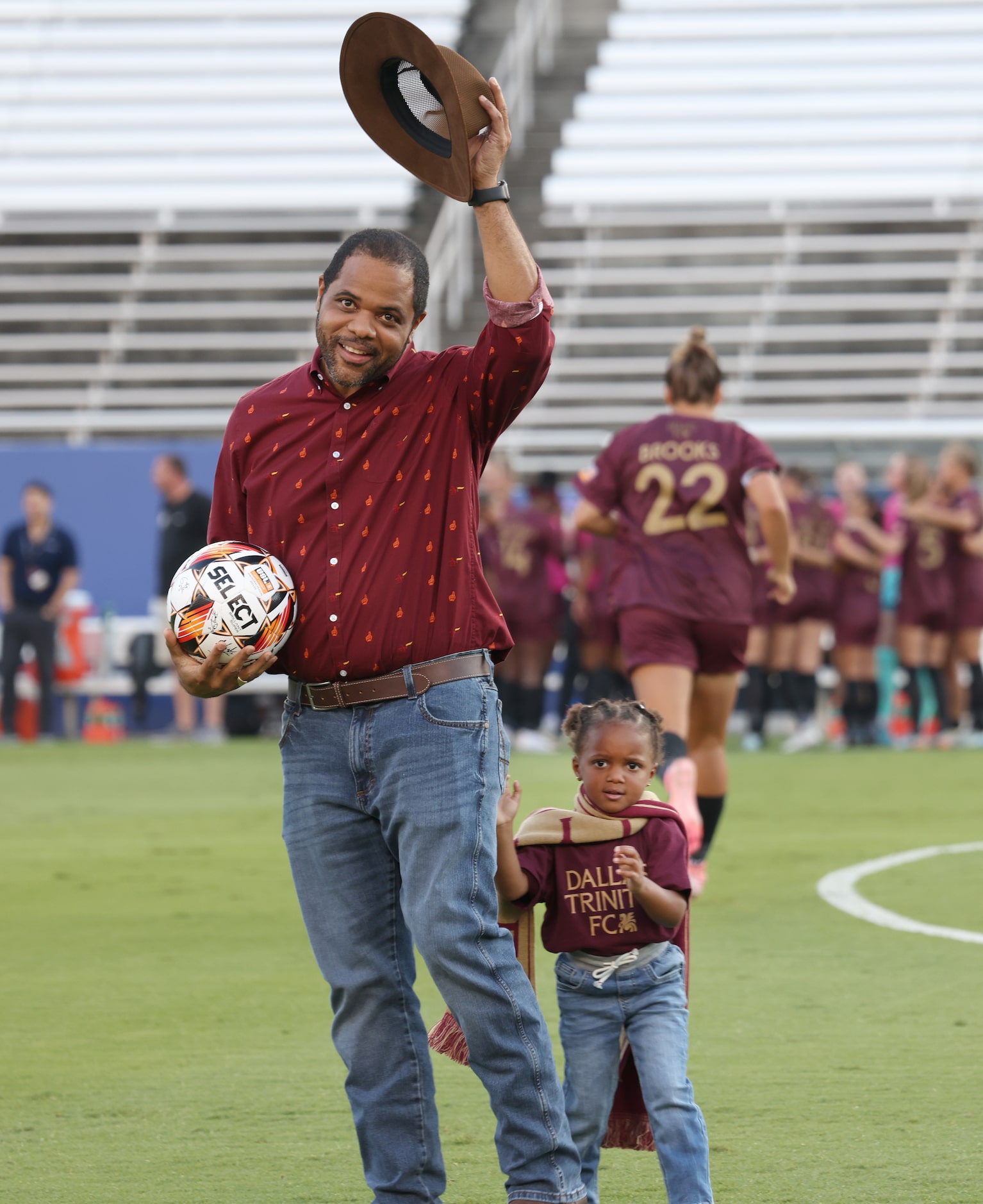 Dallas Mayor Eric Johnson tips his hat to an enthusiastic crowd as Lela Johnson sports a...