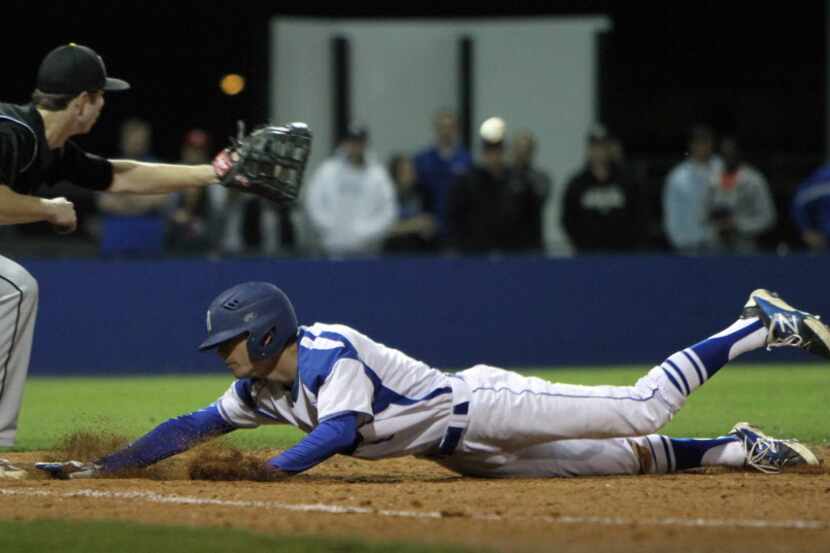 Midlothian outfielder Blake Laney (8) dives back into first base ahead of the tag by...