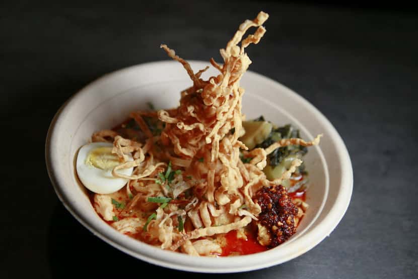 Khan Soi served with egg noodle, chicken, curry soup, shallots, chili oil & boiled egg, form...