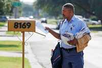 Jonathan O’Hara, a letter carrier for the U.S. Postal Service, delivers mail on his route...