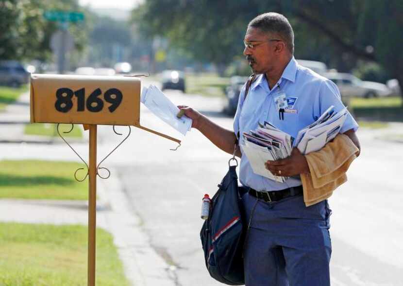 
Jonathan O’Hara, a letter carrier for the U.S. Postal Service, delivers mail on his route...