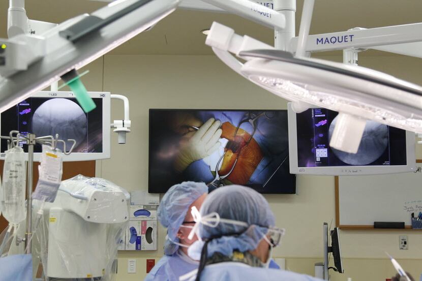 At Texas Health Arlington Memorial Hospital, a doctor performs spinal surgery in 2014. It's...