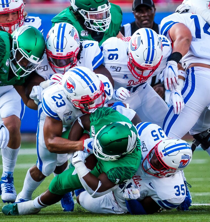 UNT running back DeAndre Torrey (13) is brought down by SMU safety Rodney Clemons (23),...