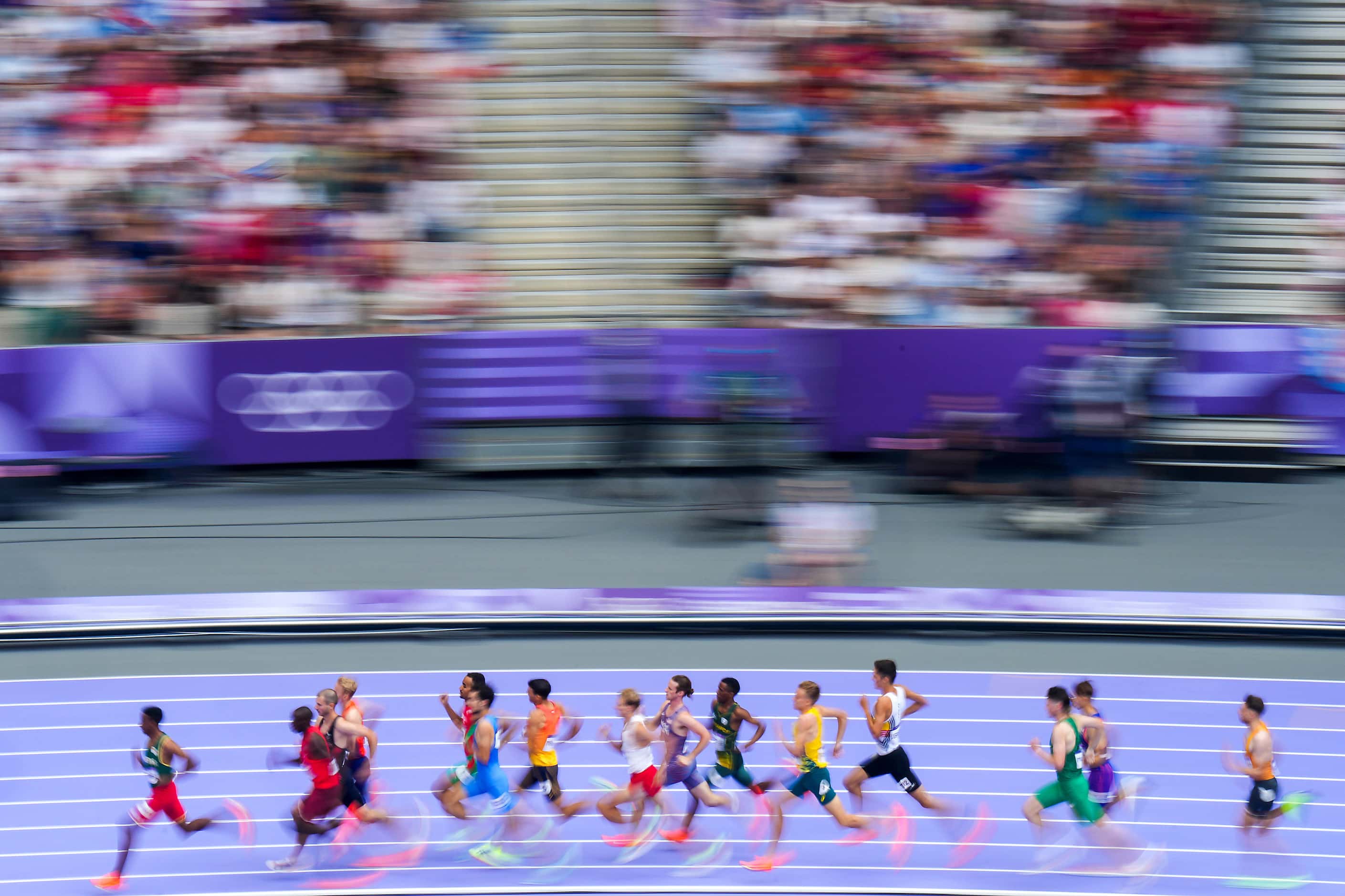 Runners in a the second heat of the men’s 1500-meters round a curve of the track at the 2024...