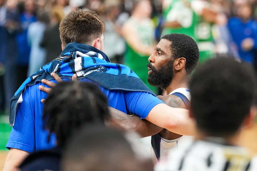 Dallas Mavericks guard Kyrie Irving (facing) hugs guard Luka Doncic time expires on a loss...