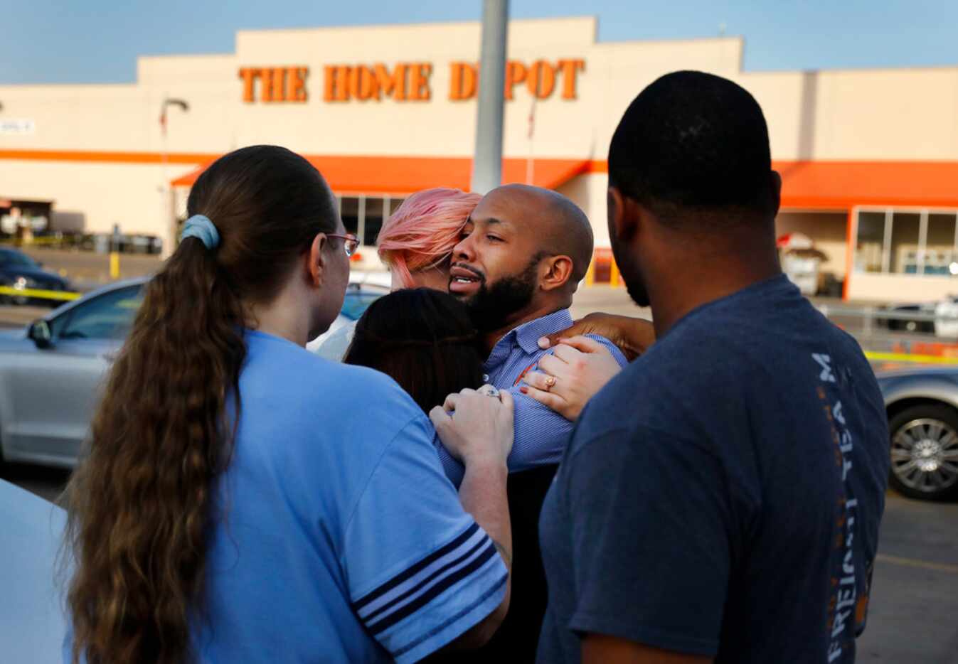 Home Depot employees comfort each other outside the Dallas store after two officers and a...