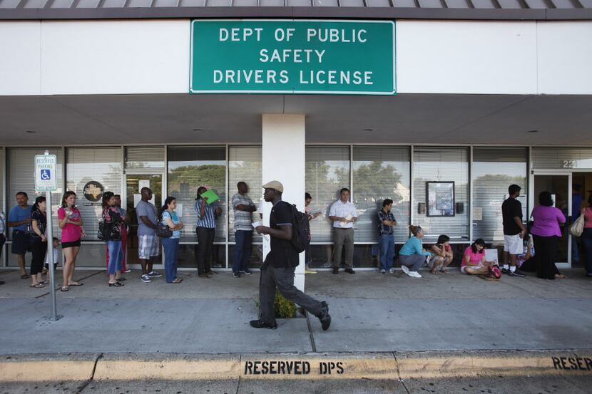 People wait just outside the Texas Department of Public Safety office in Plano. (2012 File...