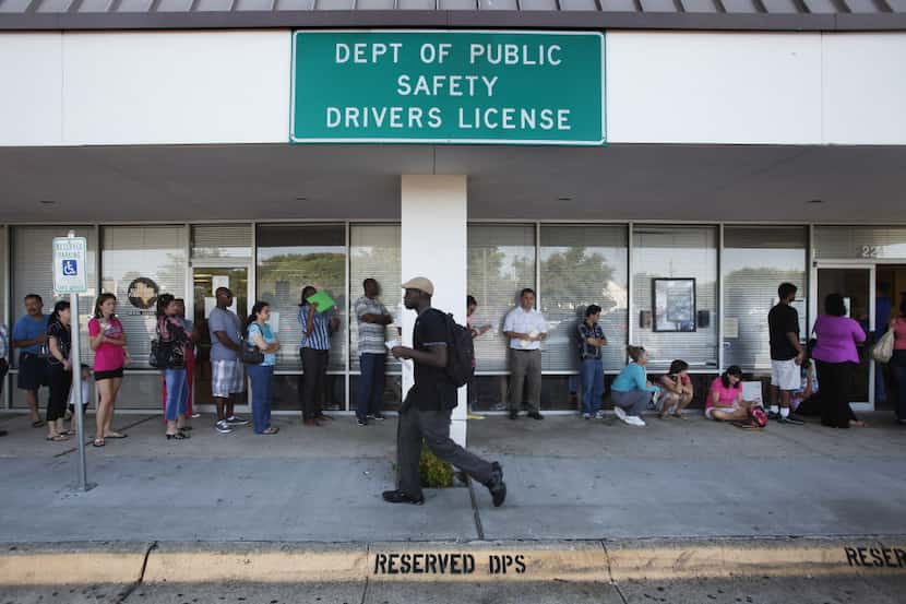  People wait just outside the Texas Department of Public Safety office in Plano. (2012 File...