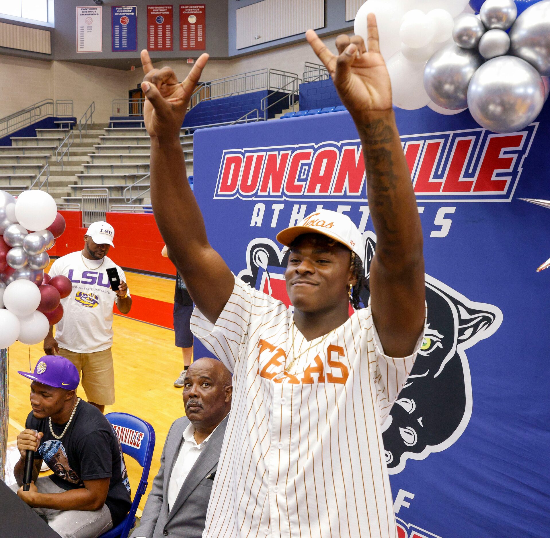 Duncanville defensive lineman Colin Simmons holds up “Hook ‘em Horns” before speaking with...