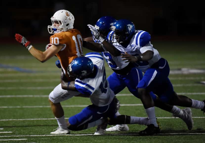 Arlington Bowie's Ty DeArman (10) is tackled by North Mesquite defenders including Davion...