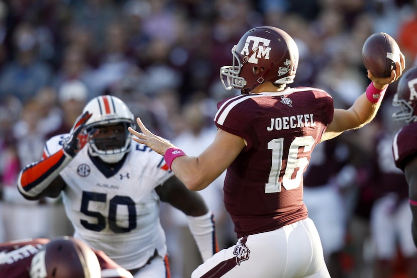 Matt Joeckel of the Texas A&M Aggies in the pocket while Ben Bradley of the Auburn Tigers...